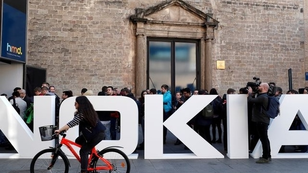 FILE PHOTO: A cyclist rides past a Nokia logo during the Mobile World Congress in Barcelona, Spain February 25, 2018. REUTERS/Yves Herman/File Photo