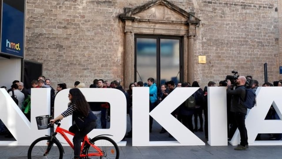 FILE PHOTO: A cyclist rides past a Nokia logo during the Mobile World Congress in Barcelona, Spain February 25, 2018. REUTERS/Yves Herman/File Photo