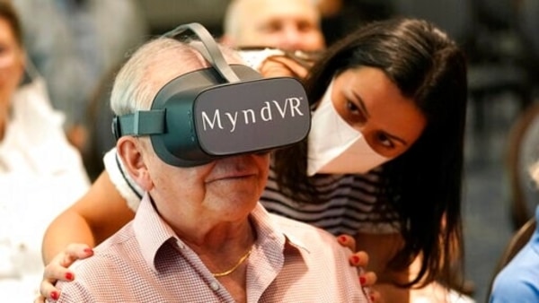 Gloria Gantes, right, monitors Terry Colli, a resident of John Knox Village, as he participates in a virtual reality study, Tuesday, June 1, 2021, in Pompano Beach, Fla. The senior community is in partnership with Stanford University's Virtual Human Interaction Lab on a study to see how older adults respond to virtual reality and whether it can improve their sense of wellbeing. (AP Photo/Lynne Sladky)