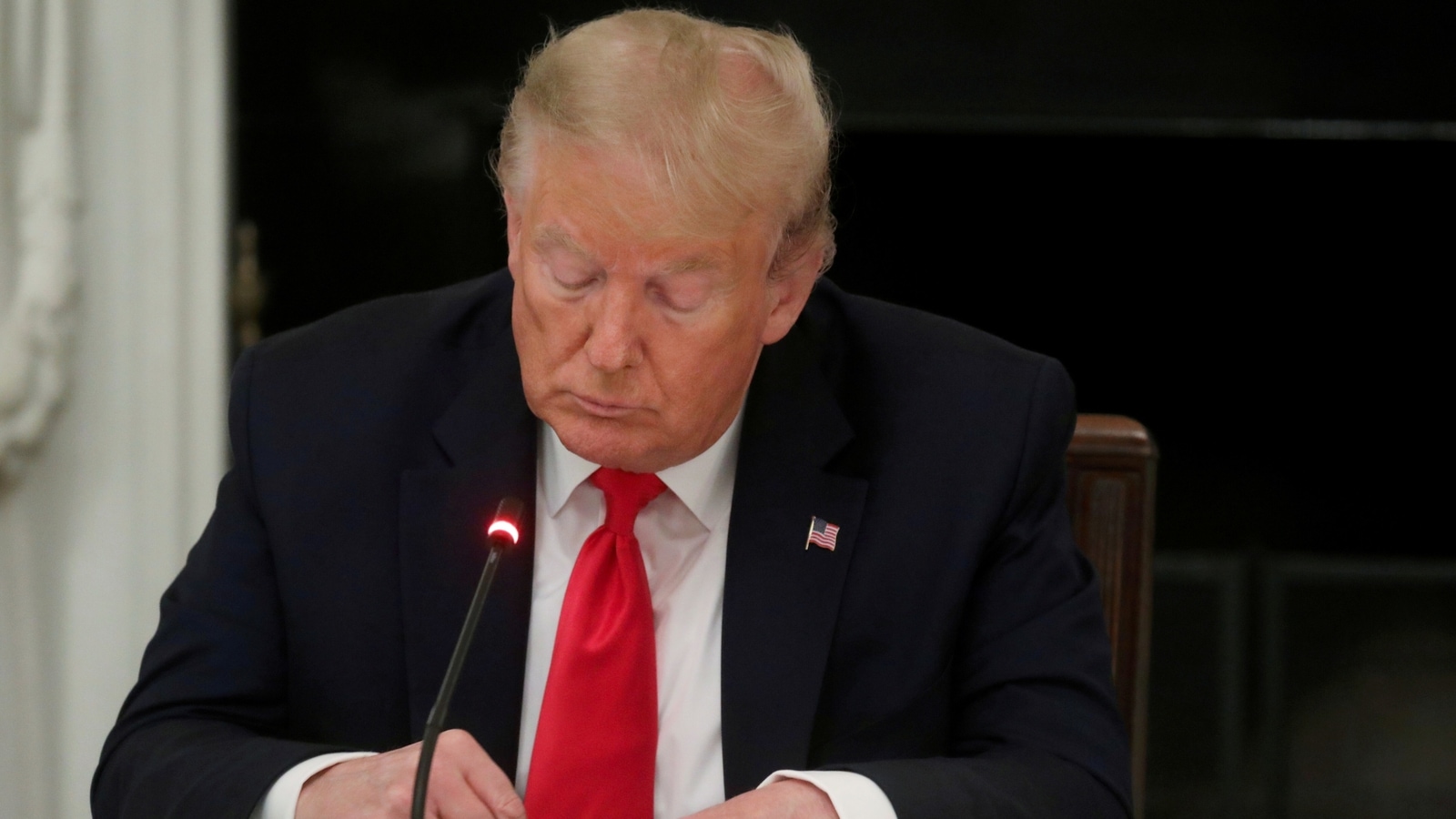 FILE PHOTO: U.S. President Donald Trump is seen tapping the screen on a mobile phone at the White House in Washington, U.S., June 18, 2020. 