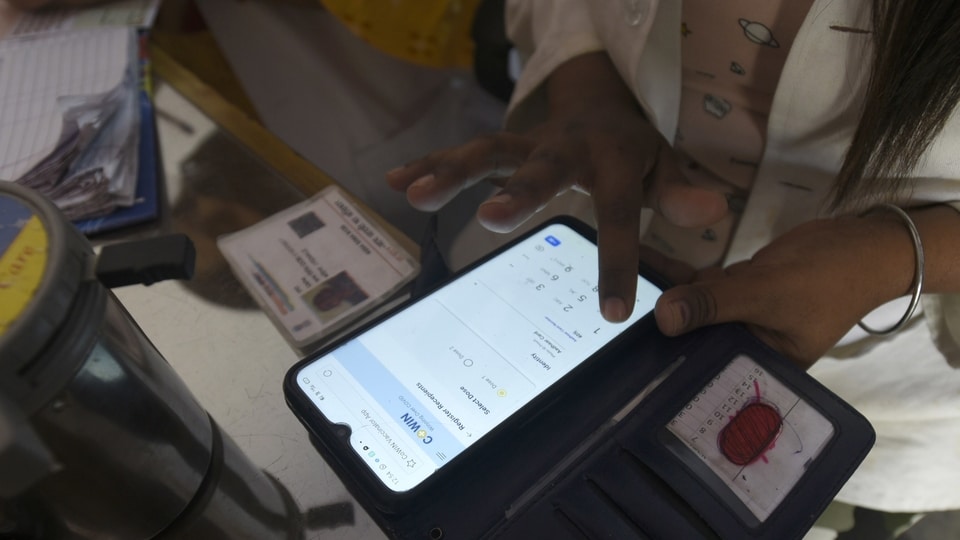 FILE PHOTO: A health worker registering a person on the CoWin app for Covid-19 vaccination, at sector 22 (UPHC) urban primary health centre, in Noida, India, on Thursday, March 25, 2021. 