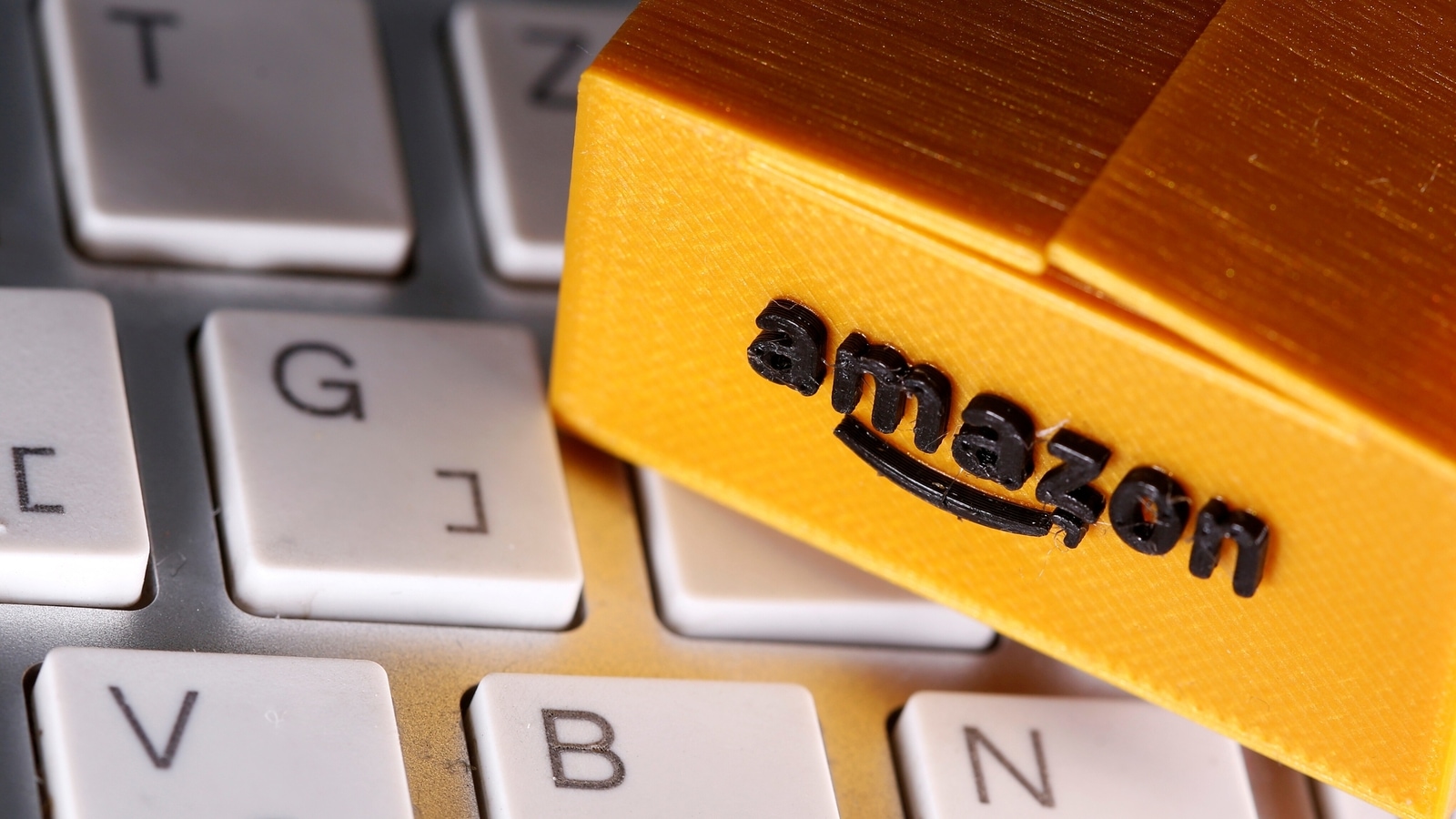 FILE PHOTO: FILE PHOTO: A 3D printed Amazon postal package is placed on a keyboard in this illustration taken March 25, 2020. 