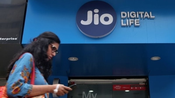 A woman checks her mobile phone as she walks past a mobile store of Reliance Industries' Jio telecoms unit, in Mumbai, India, July 11, 2017. REUTERS/Shailesh Andrade/Files