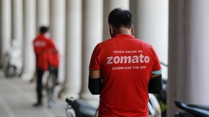 A delivery worker of Zomato, an Indian food-delivery startup, waits to collect an order from a restaurant in New Delhi, India, May 21, 2020. REUTERS/Anushree Fadnavis/File Photo
