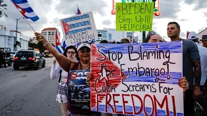 People hold Cuban flags and placards during a protest showing support for Cubans demonstrating against their government, in Miami, Florida on July 16, 2021.