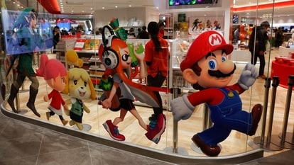 FILE - In this Jan. 23, 2020, file photo, Nintendo characters, including Mario, right, are seen on a glass of its official store in Tokyo. Nintendo’s April-June profit declined 13% from the same period the previous year, when the hit game “Animal Crossing: New Horizons” had dramatically boosted sales. (AP Photo/Jae C. Hong, File)