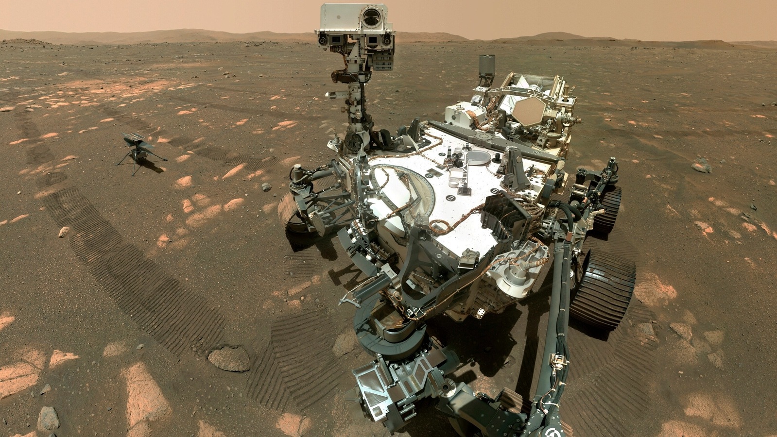 This Tuesday, April 6, 2021 image made available by NASA shows the Perseverance Mars rover, foreground, and the Ingenuity helicopter about 13 feet (3.9 meters) behind. This composite image was made by the WASTON camera on the rover's robotic arm on the 46th Martian day, or sol, of the mission. On Friday, Aug. 6, 2021, NASA’s newest Mars rover came up empty in its first attempt to pick up a rock sample to eventually be brought back to Earth. 