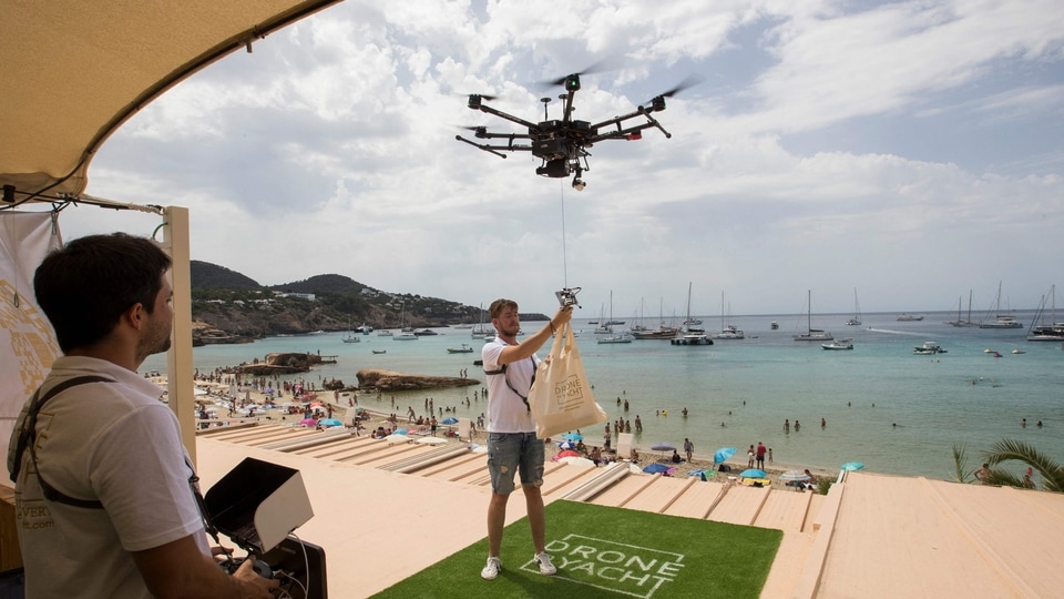 Representational image: A drone pilot ties up a bag of food to a drone at Cala Tadira near Sant Josep de Sa Talaia in Ibiza Island on August 24, 2021. (Photo by JAIME REINA / AFP)