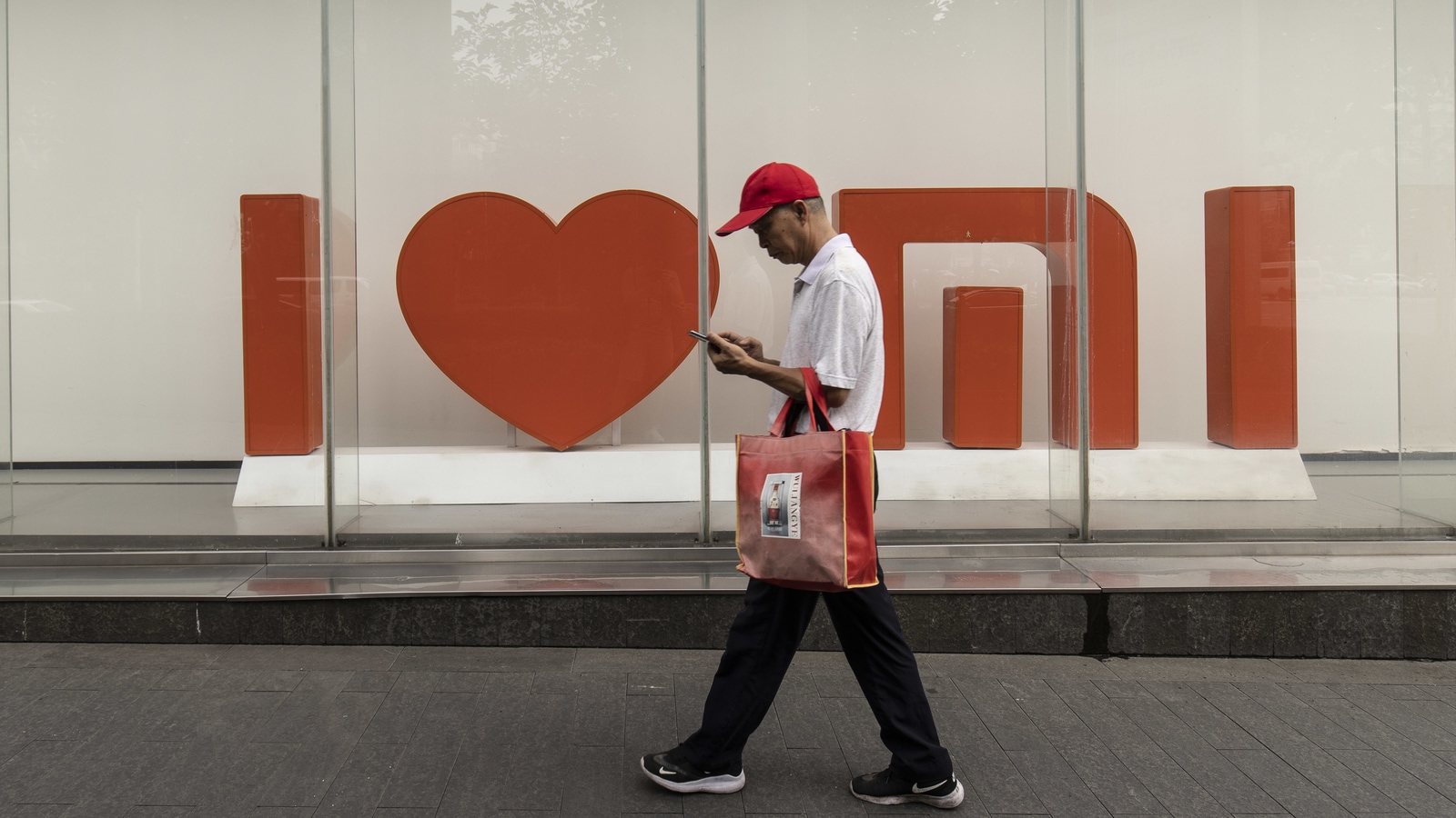 A pedestrian in front of a Xiaomi Corp. store in Shanghai, China, on Tuesday, Aug. 24, 2021. Photographer: Qilai Shen/Bloomberg