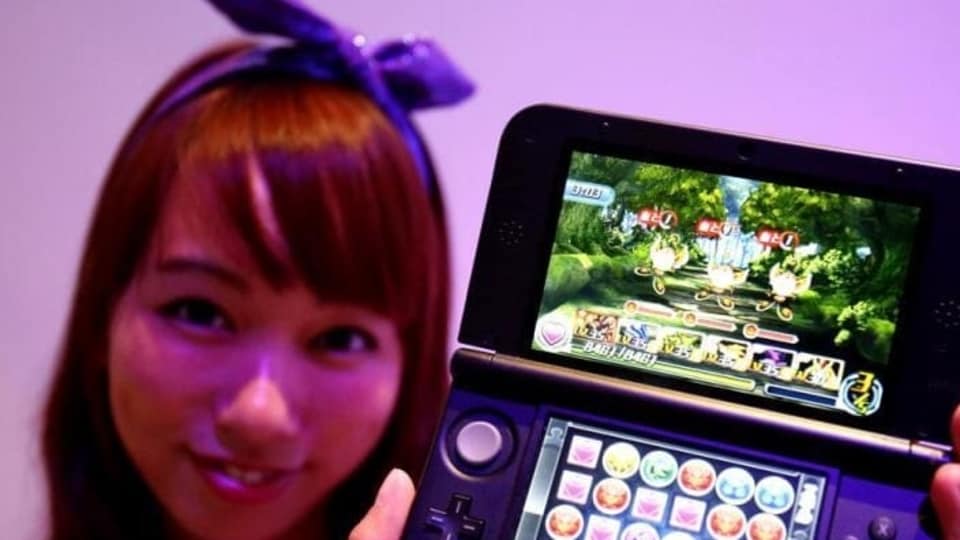 A booth girl holds a Nintendo 3DS displaying GungHo Online Entertainment Inc's new game 'Puzzle & Dragons Z' at the Tokyo Game Show in Chiba, east of Tokyo. 
