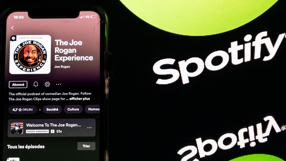Joe Rogan podcast and a screen displaying the Spotify logo. Spotify