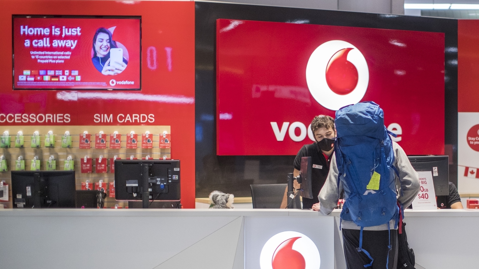 A traveler stands at a Vodafone kiosk at the international terminal of Sydney Airport in Sydney, Australia. vodafone
