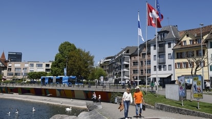 Visitors walk along the waterfront of Lake Zug in Zug, Switzerland. Zug, known for its low corporate taxes and commodities traders, has become a hub for cryptocurrency firms, accepting Bitcoin as payment for some services since 2016.