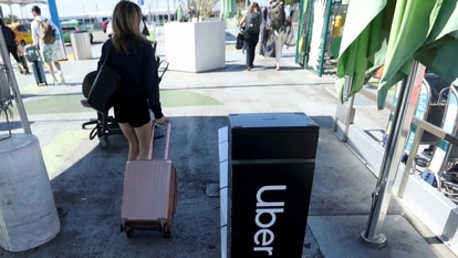 A passenger walks near Uber signage after arriving at Los Angeles International Airport (LAX) in Los Angeles, California, U.S. July 10, 2022.  REUTERS/David Swanson