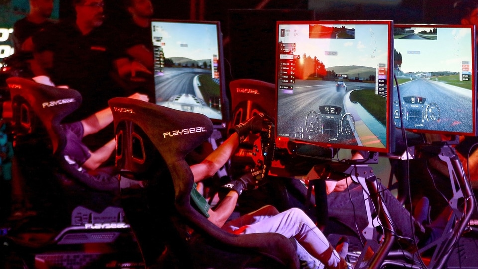 Boys play a racing game in an arcade.