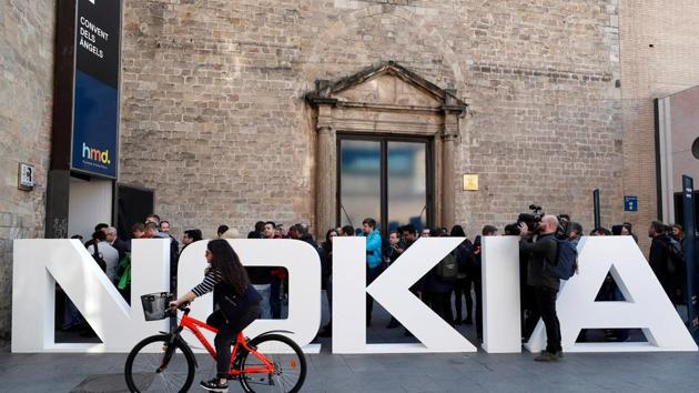 FILE PHOTO: A cyclist rides past a Nokia logo during the Mobile World Congress in Barcelona, Spain February 25, 2018. REUTERS/Yves Herman/File Photo