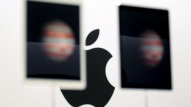 The Apple logo is seen behind new Apple iPad Pros on display during an Apple media event in San Francisco.