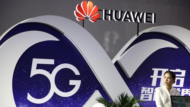 A woman stands at the booth of Huawei featuring 5G technology at the PT Expo in Beijing, China September 28, 2018. Picture taken September 28, 2018. REUTERS/Stringer ATTENTION EDITORS - THIS IMAGE WAS PROVIDED BY A THIRD PARTY. CHINA OUT.