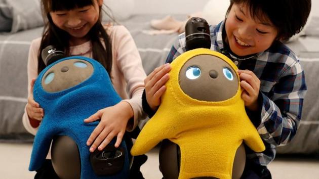 (Representative image) Children hold GROOVE X's new home robot LOVOT at its demonstration during the launch event in Tokyo