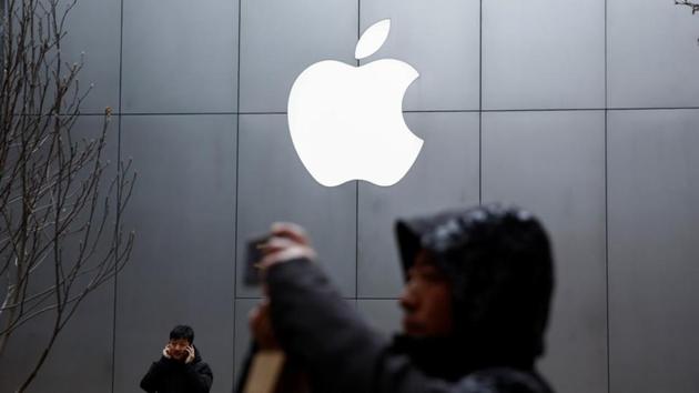 People use their phones outside an Apple store in Beijing, China January 7, 2019.