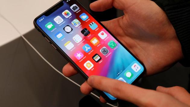 FILE PHOTO: A customer tests a smartphone during the launch of the new iPhone XS and XS Max sales at 