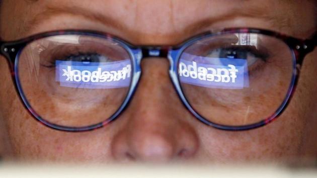 The Facebook logo is reflected on a woman's glasses in this photo illustration taken June 3, 2018. REUTERS/Regis Duvignau/Illustration