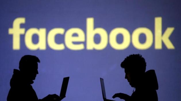 FILE PHOTO: Silhouettes of laptop users are seen next to a screen projection of Facebook logo in this picture illustration taken March 28, 2018. REUTERS/Dado Ruvic/Illustration/File Photo