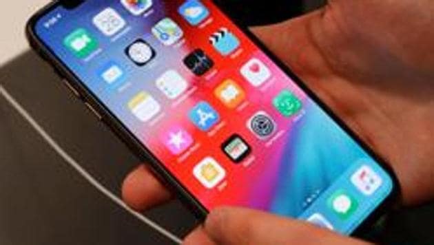 FILE PHOTO: A customer tests a smartphone during the launch of the new iPhone XS and XS Max sales at 