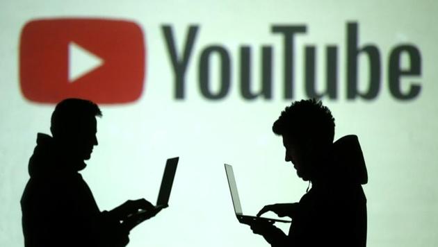 FILE PHOTO: Silhouettes of mobile device users are seen next to a screen projection of Youtube logo in this picture illustration taken March 28, 2018. REUTERS/Dado Ruvic/File Photo