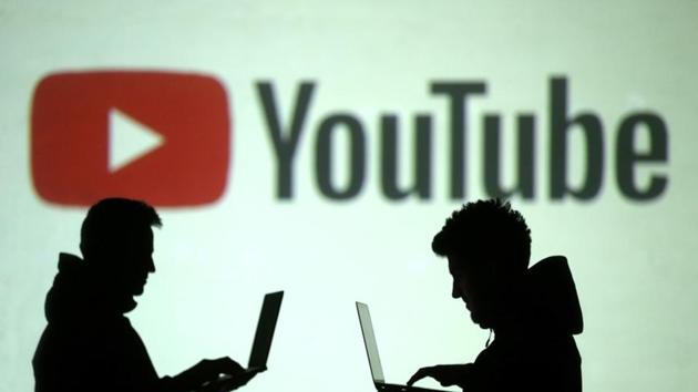 FILE PHOTO: Silhouettes of mobile device users are seen next to a screen projection of Youtube logo in this picture illustration taken March 28, 2018. REUTERS/Dado Ruvic/File Photo