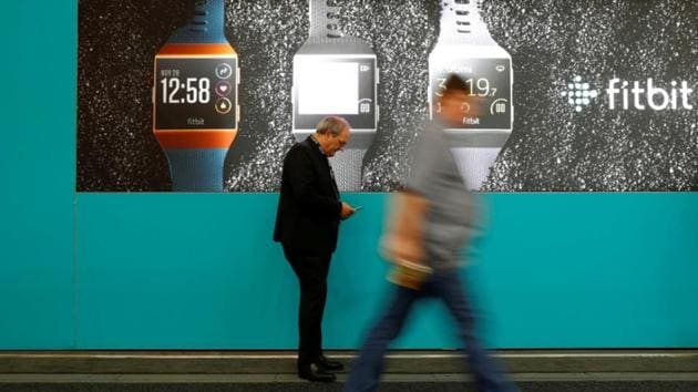 Visitors walk past an advertising billboard for Fitbit Ionic watches at the IFA Electronics Show in Berlin, Germany, September 1, 2017.