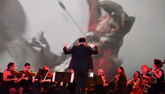 The Assassin's Creed Symphony performs on stage, June 10, 2019 at the Ubisoft E3 press conference in Los Angeles. - The Assassin's Creed Symphony, a multimedia concert combining special effects and HD footage on giant screens from over a decade of Assassin's Creed features a live orchestra and choir. The E3 Electronic Entertainment Expo takes place at the Los Angeles Convention Center June 11-13.
