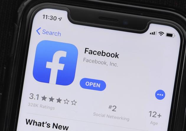 This Monday, July 30, 2019 photo shows an update information of Facebook application on a mobile phone displayed at a store in Chicago. The FBI is looking for outside contractors to monitor social media for potential threats, setting up a possible conflict with Facebook and other companies over privacy.