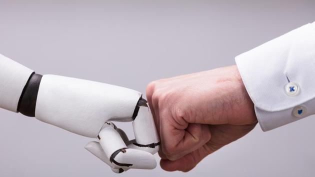 Robot And Human Hand Making Fist Bump On Grey Background