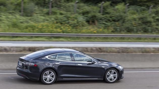 Black Tesla Model S luxury electric sedan on the highway.