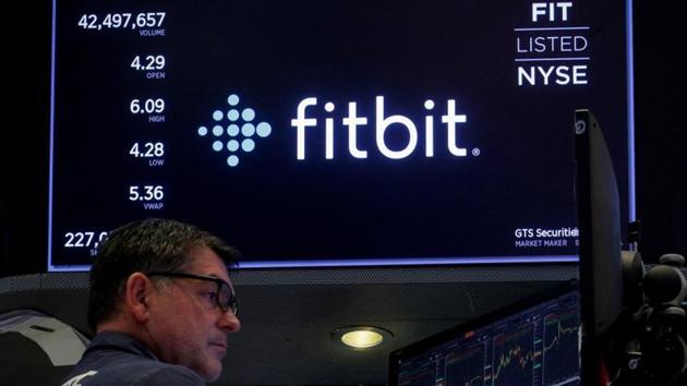 FILE PHOTO: A trader works at his post as the logo for wearable device maker Fitbit Inc. is displayed on a screen on the floor of the New York Stock Exchange (NYSE) as begins public trading in New York, U.S., October 28, 2019. REUTERS/Brendan McDermid