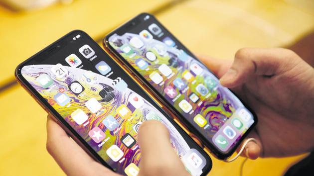A customer compares the size of the new iPhone XS and iPhone XS Max at the Apple Store in Singapore September 21, 2018. REUTERS/Edgar Su - RC11F423A010