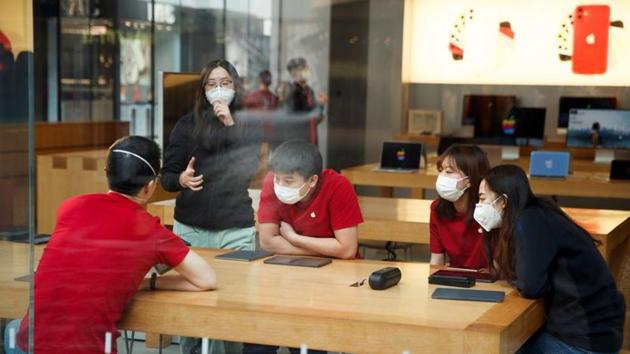 People wear face masks as they listen to a presentation in an Apple Store in the Sanlitun shopping district in Beijing as China is hit by an outbreak of the new coronavirus, January 25, 2020.