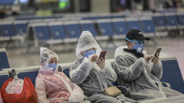 A family wearing masks and make-shift protection gear wait for their train at the Hongqiao High-speed Railway Station in Shanghai, China, on Tuesday, Feb. 11, 2020. The death toll from the coronavirus climbed above 1,000, as the Chinese province at the epicenter of the outbreak reported its highest number of fatalities yet.