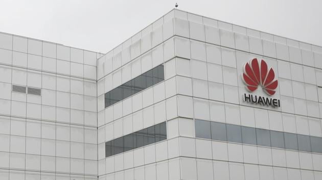 Employees of Huawei Technologies Co. Ltd. walk past the company office in Shenzhen, Guangdong.