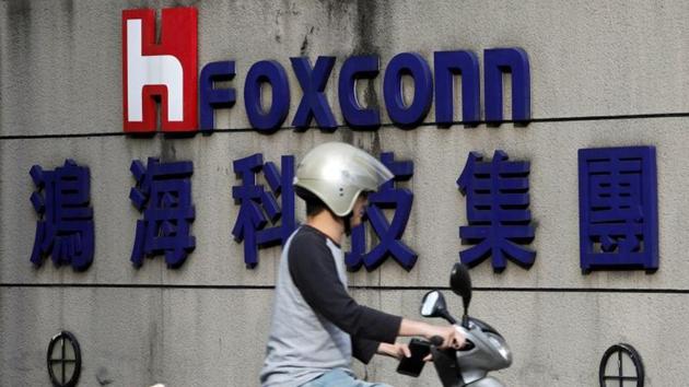 A motorcyclist rides past the logo of Foxconn, the trading name of Hon Hai Precision Industry, in Taipei, Taiwan March 30, 2018.