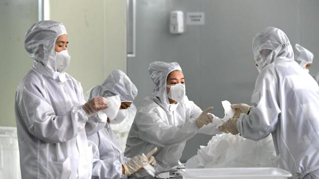 Employees work on a production line manufacturing face masks at a factory, as the country is hit by an outbreak of the novel coronavirus, in Fuzhou, Fujian province, China February 15, 2020.
