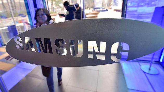 A woman walks past the logo of Samsung Electronics at its showroom in Seoul.
