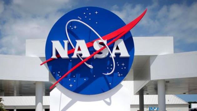 Tourists take pictures of a NASA sign at the Kennedy Space Center visitors complex in Cape Canaveral, Florida April 14, 2010. REUTERS/Carlos Barria/Files