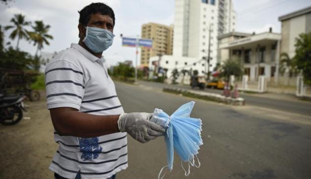 An Indian man sells face masks by a roadside in Kochi, Kerala, India, Saturday, May 2, 2020. The southern state has made wearing face masks mandatory in public places and work places as part of measures to curb the spread of the new coronavirus.