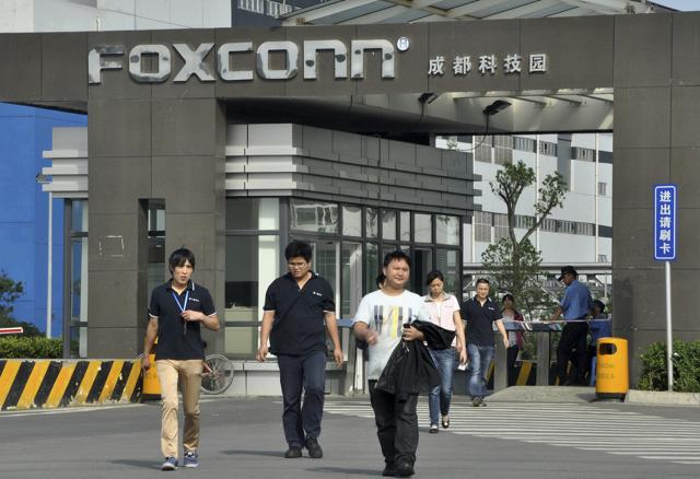 Workers walk out of the entrance to a Foxconn factory in Chengdu, Sichuan province. Workers walk out of the entrance to a Foxconn factory in Chengdu, Sichuan province.