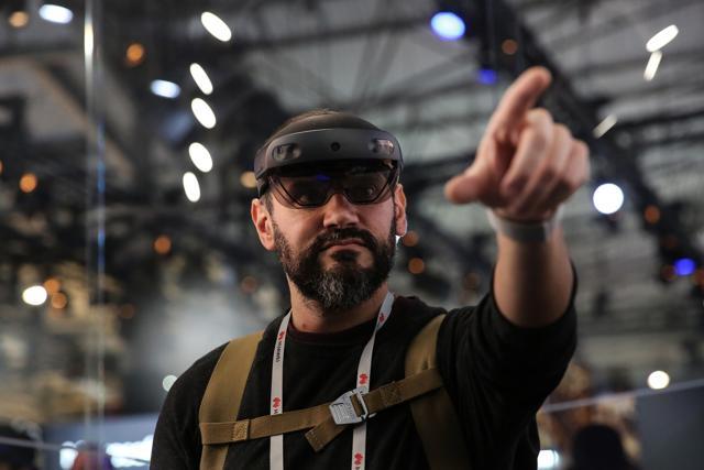 An attendee wears a Microsoft Corp. HoloLens 2 headset as he uses the Bentley Systems Inc. Synchro XR augmented reality (AR) app, at the Microsoft Corp. stand on the opening day of the MWC Barcelona An attendee wears a Microsoft Corp. HoloLens 2 headset as he uses the Bentley Systems Inc. Synchro XR augmented reality (AR) app, at the Microsoft Corp. stand on the opening day of the MWC Barcelona