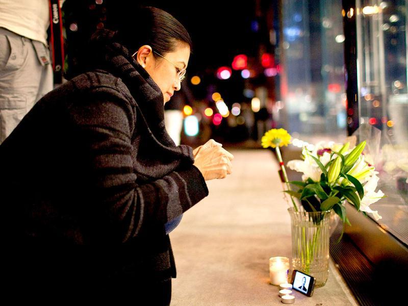 Surina Shukri lights a candle in remembrance of Steve Jobs outside the Apple Store at West 66th Street in New York. Surina Shukri lights a candle in remembrance of Steve Jobs outside the Apple Store at West 66th Street in New York.