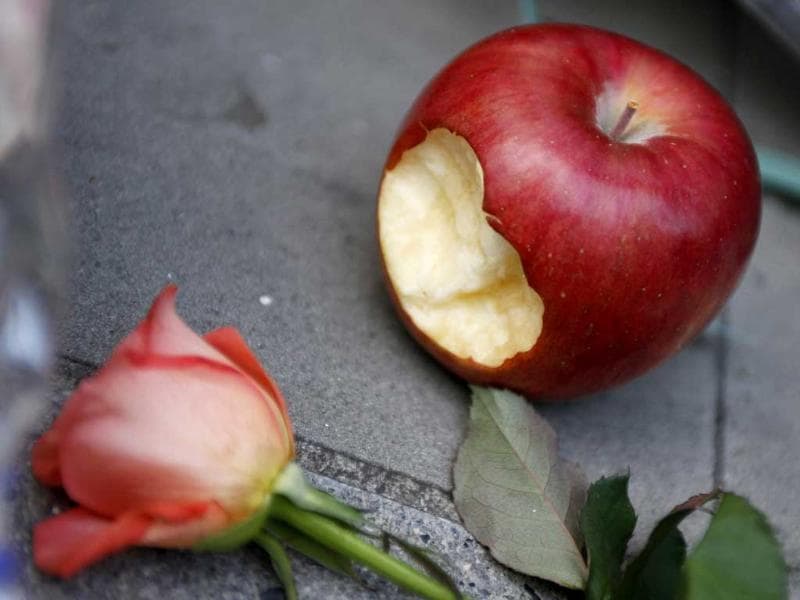 An apple is placed next to a flower offered in memory of Apple co-founder Steve Jobs at the entrance of the Shibuya Apple store in Tokyo. An apple is placed next to a flower offered in memory of Apple co-founder Steve Jobs at the entrance of the Shibuya Apple store in Tokyo.