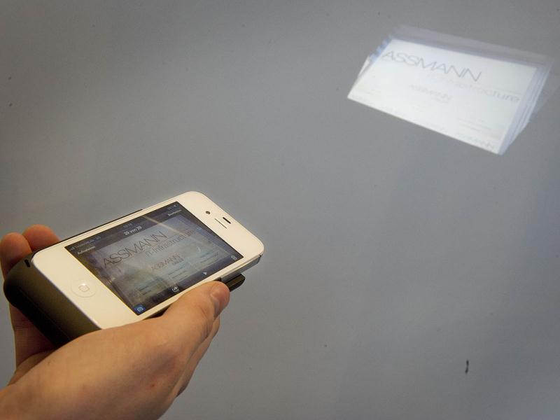 The company Assmann shows the Iphone jacket with a built in projector at the world's biggest high-tech fair, the CeBIT, on March 6, 2012 in Hanover, central Germany. Brazil is the partner country of the CeBIT 2012, which is running until March 10. The device that slips onto the Iphone will project pictures, movies and presentations on any blank surface. AFP PHOTO / ODD ANDERSEN The company Assmann shows the Iphone jacket with a built in projector at the world's biggest high-tech fair, the CeBIT, on March 6, 2012 in Hanover, central Germany. Brazil is the partner country of the CeBIT 2012, which is running until March 10. The device that slips onto the Iphone will project pictures, movies and presentations on any blank surface. AFP PHOTO / ODD ANDERSEN